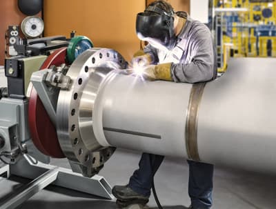 Welder at work on a roll with an ARC welding set