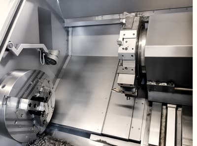 Inside a CNC lathe, chuck and tool turret machining a roll