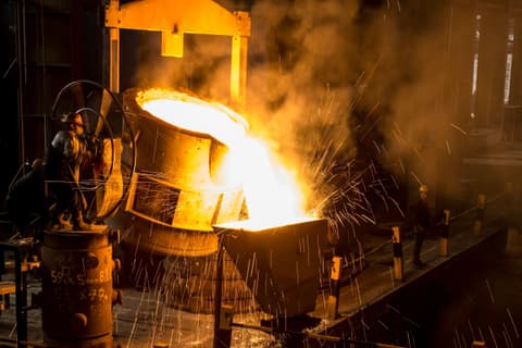 Molten metal pouring from a ladle with sparks