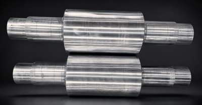 Two alloy cast steel rolls on a dark background