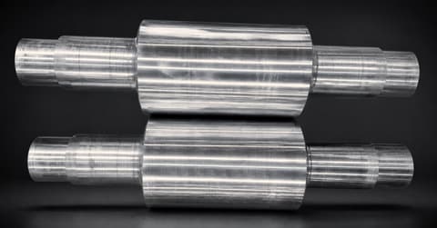 Two alloy cast steel rolls on a dark background